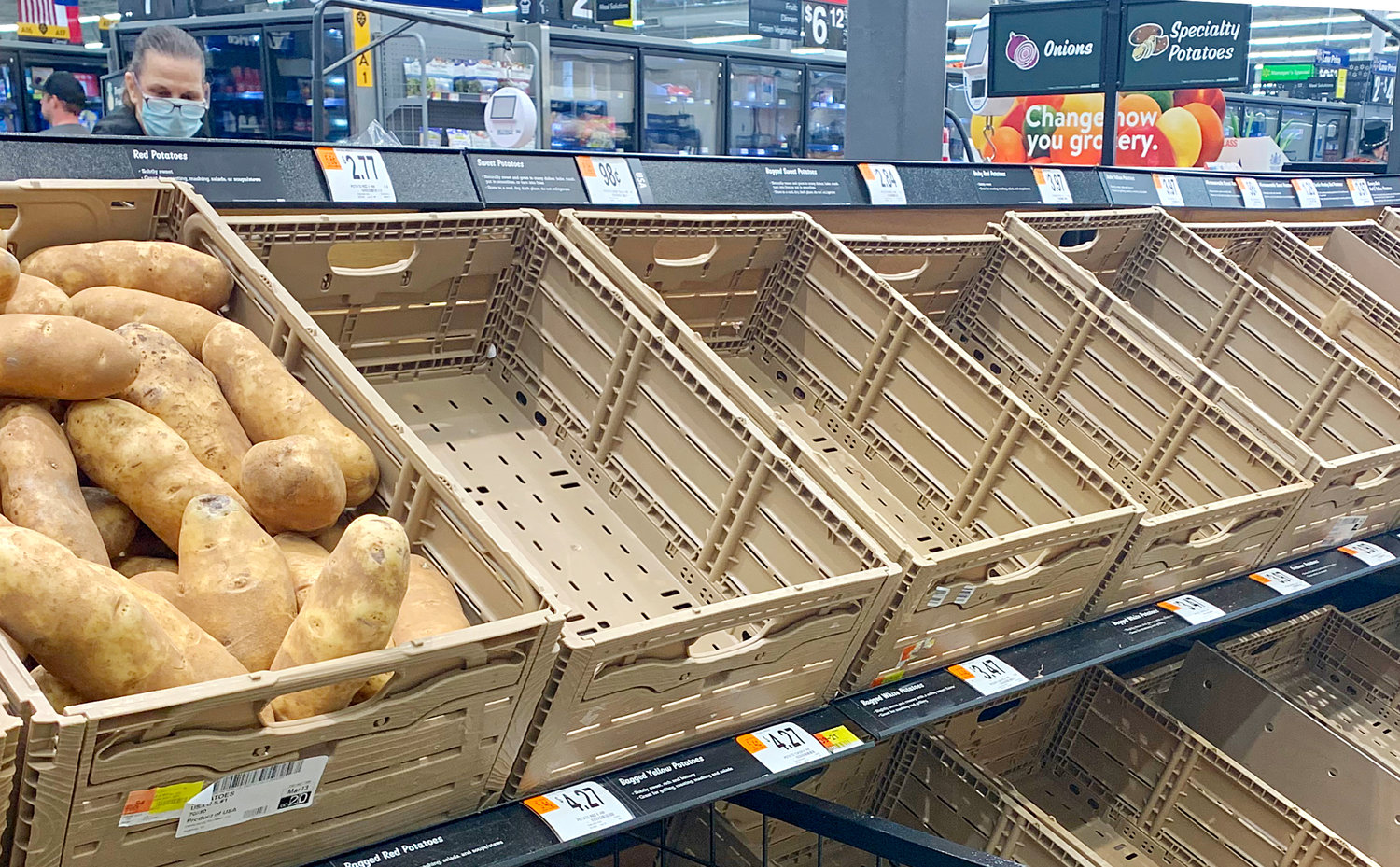 Only one lone bin of potatoes was available on a recent shopping day at Walmart as many food items and health supplies have been in high demand. Supply chains are reported to remain robust. Many citizens like the one above have starting using masks in public.